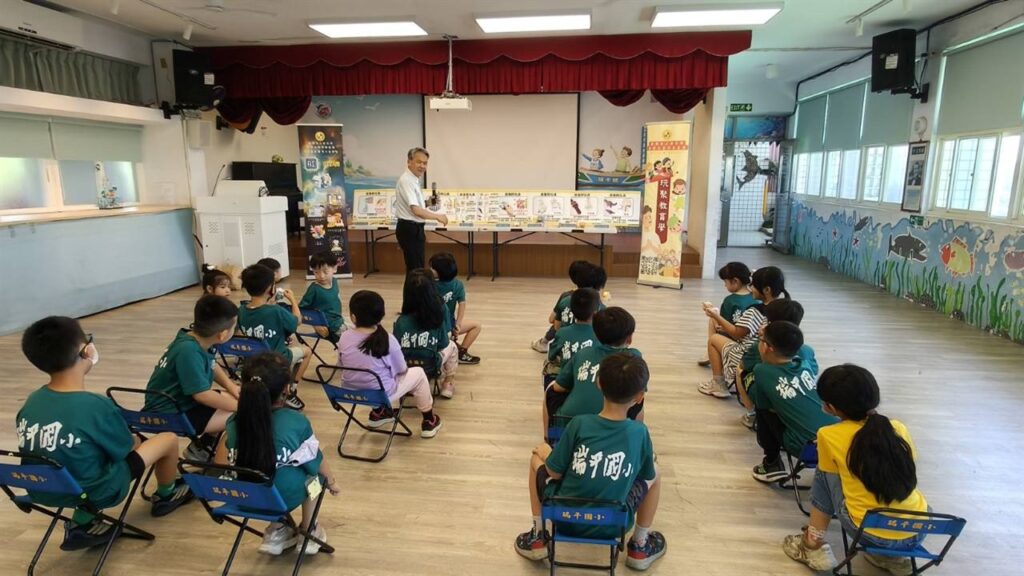 簡戊鑑教授在兒童傷害預防課程中展示玩具安全教具,學生坐在教室中聆聽