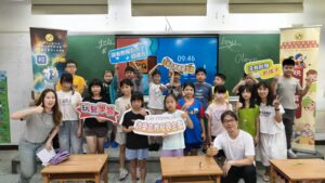 游榮吉教育基金會與興南國小英語夏令營師生合影，孩子手持玩聚學習與基金會活動手牌
