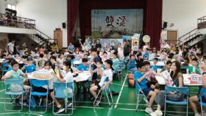 雙溪國小學生在活動會場手持 F16 手拋飛機，參與游榮吉教育基金會開學體驗活動