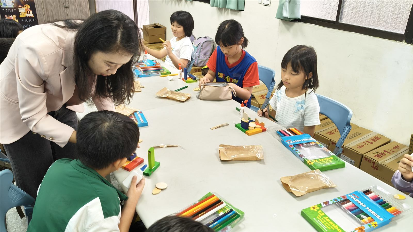興南國小學生在木樂新生小學堂中專注組合木材餘料