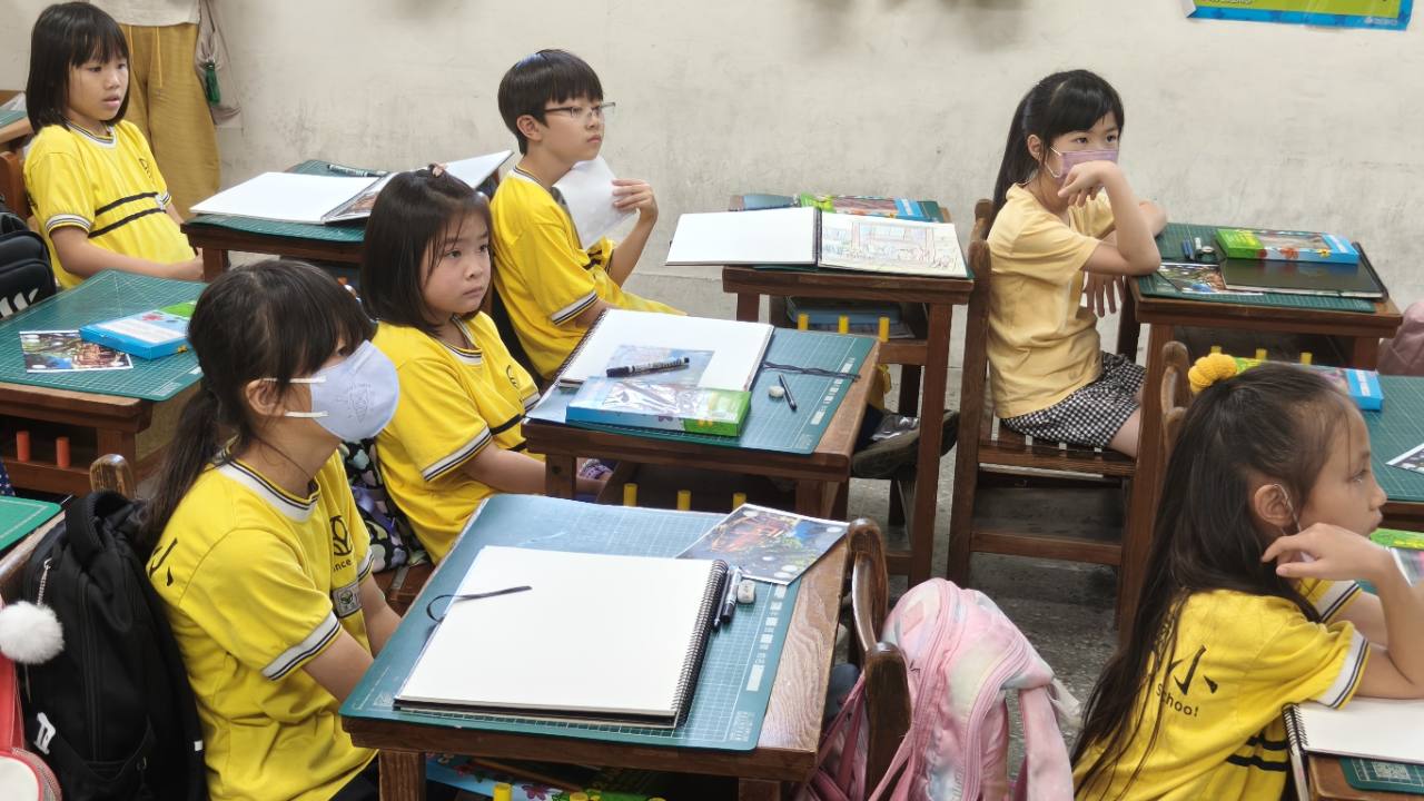 學生在畫紙前專注聆聽藝術美學課程指導